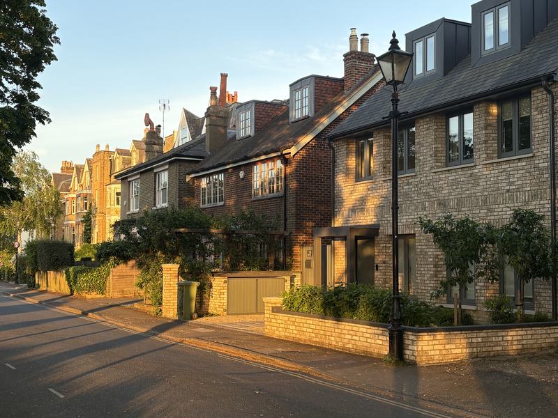 Evening sunlight on a row of brick houses and a Victorian street lamp